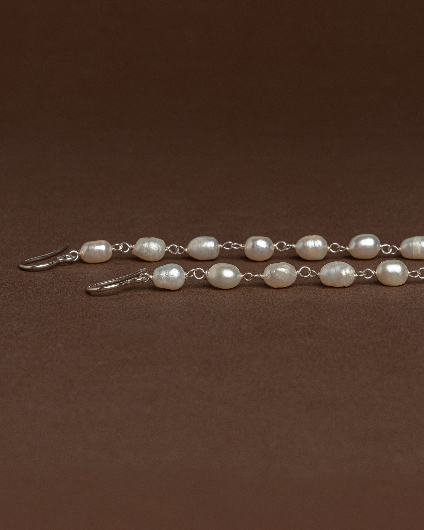 Long freshwater pearl earrings with luminous pearls and silver hooks, 14 cm in length, perfect for elegant and timeless styling.