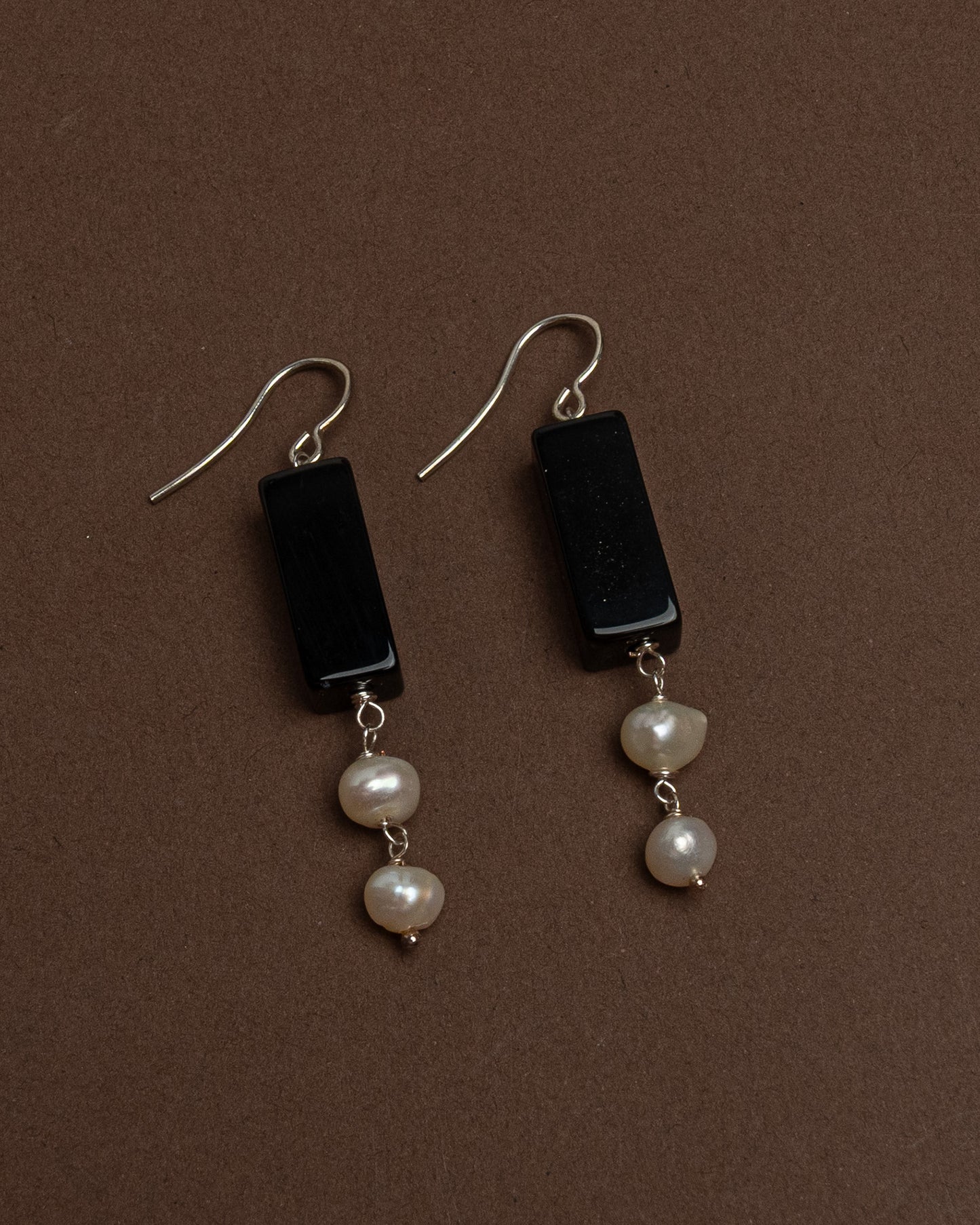 Minimalist earrings with baroque pearls and black agate. Handmade sterling silver drop earrings for modern elegance and everyday sophistication.