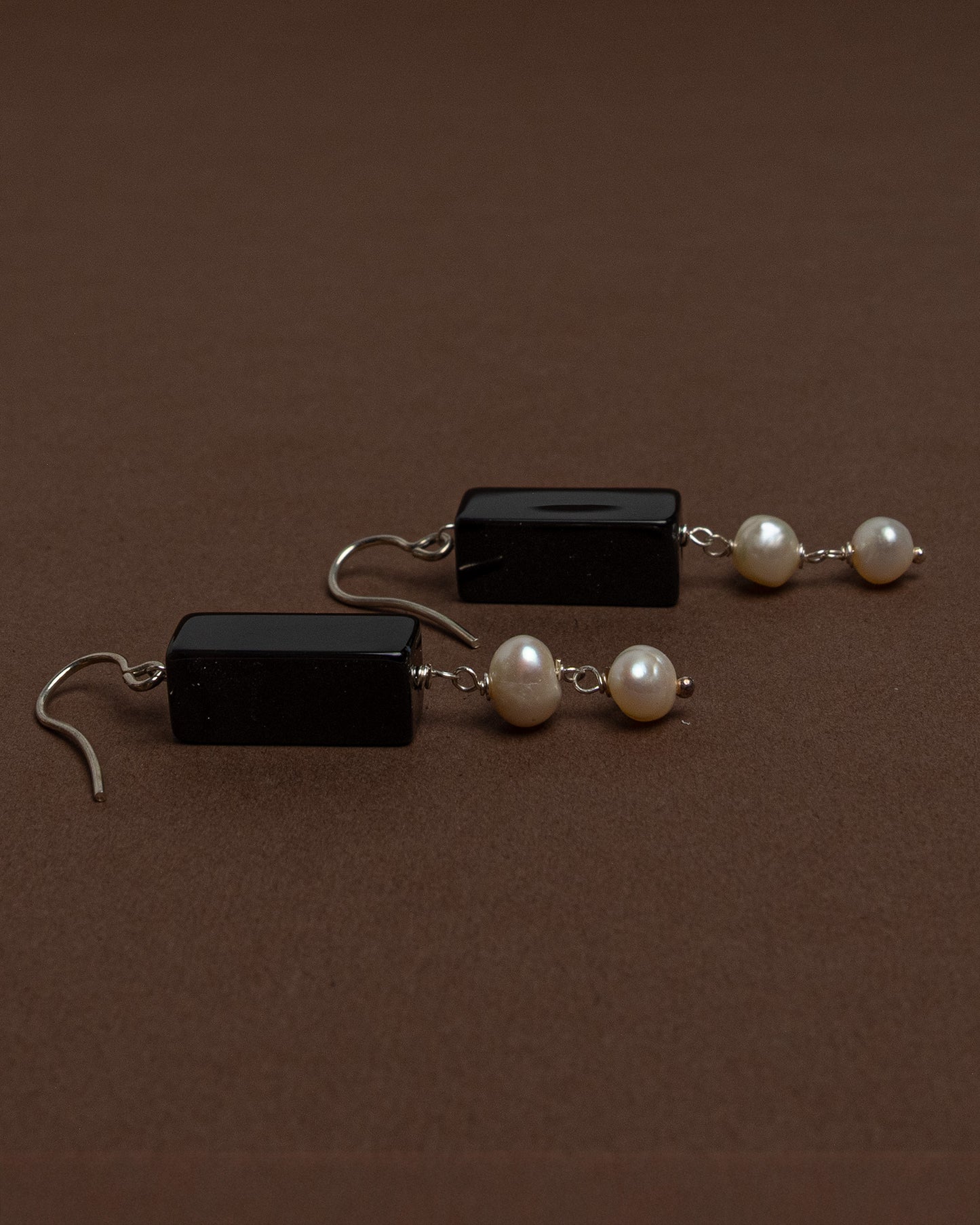 Minimalist earrings with baroque pearls and black agate. Handmade sterling silver drop earrings for modern elegance and everyday sophistication.