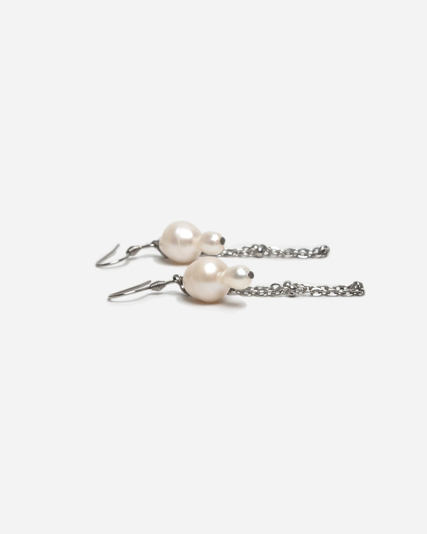 Pendientes cortos con perlas barrocas y cadena de acero inoxidable. Joyería artesanal hecha a mano en España.