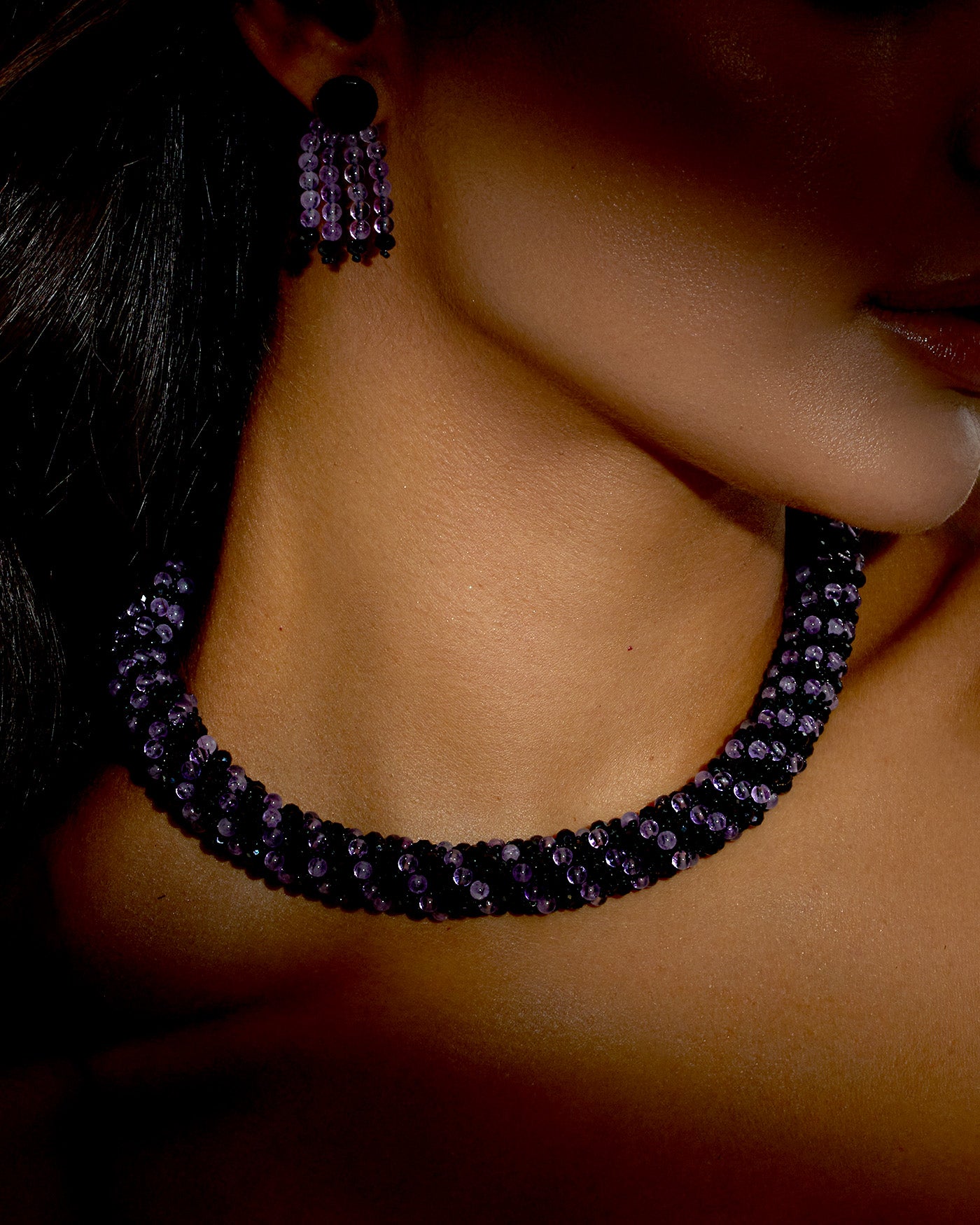 A luxurious amethyst and black spinel necklace with a silver T-bar clasp, featuring vibrant purple and dark sparkling gemstones, crafted in a collar-length design