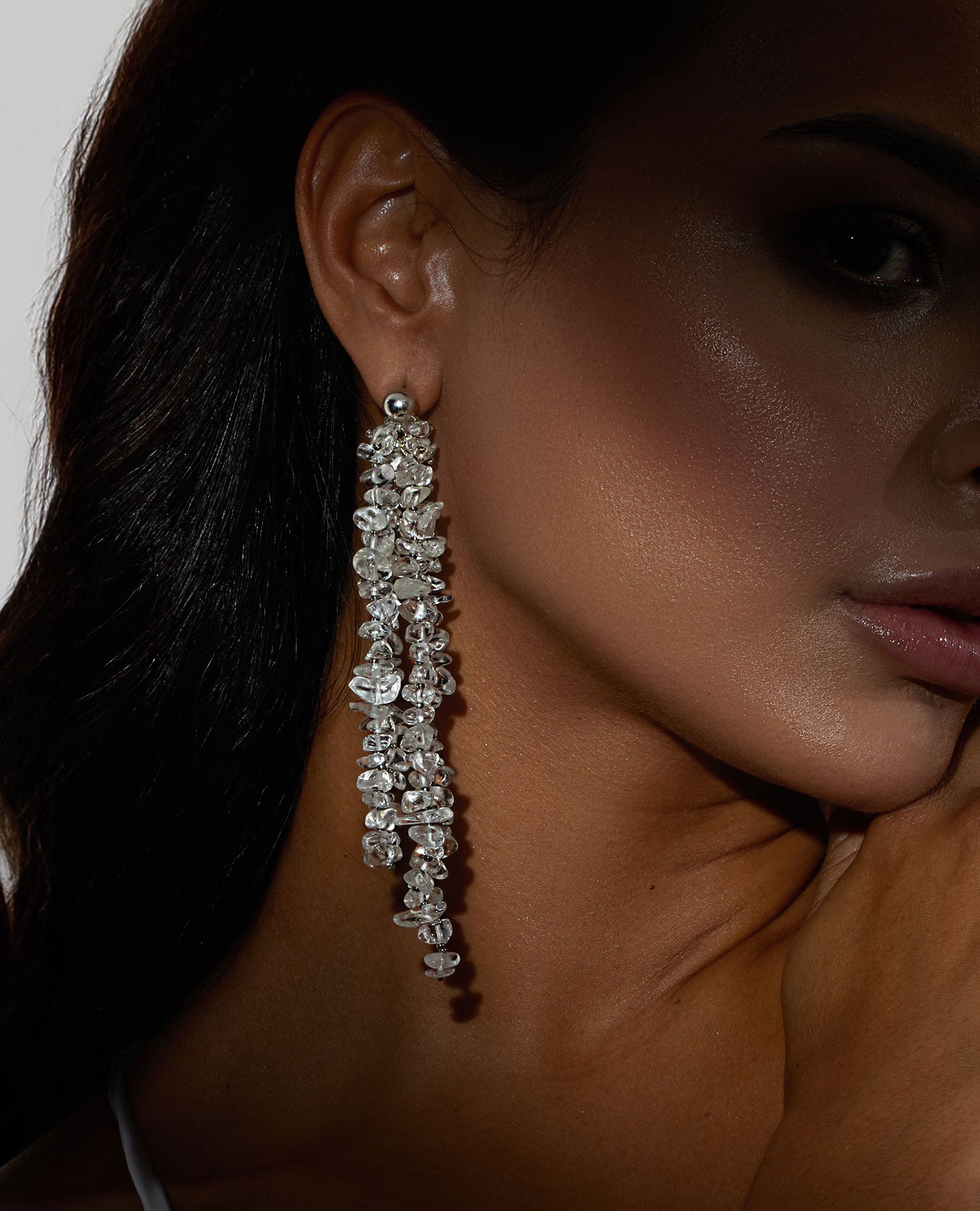 Long chunky dangling earrings featuring jagged clear quartz stones with silver hooks, 10 cm in length, offering bold and elegant design.