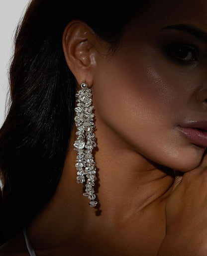 Long chunky dangling earrings featuring jagged clear quartz stones with silver hooks, 10 cm in length, offering bold and elegant design.