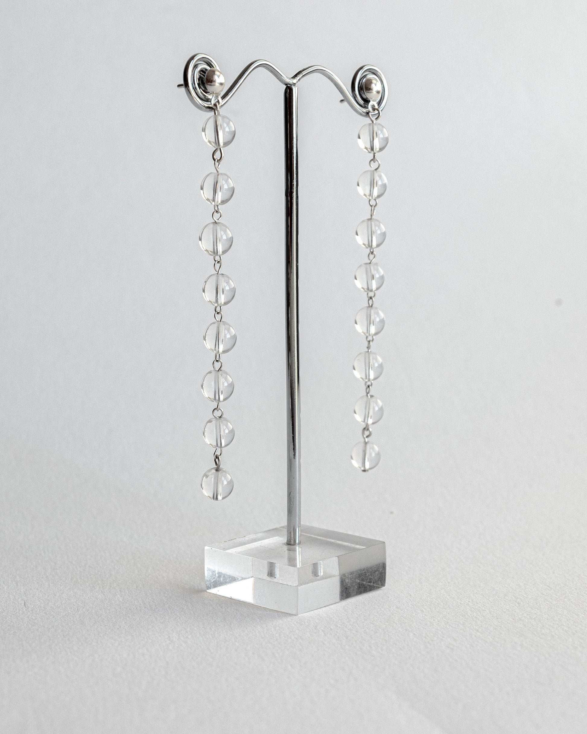 Cascading clear quartz earrings featuring transparent quartz beads in a cascading design with silver studs, 6 cm in length.