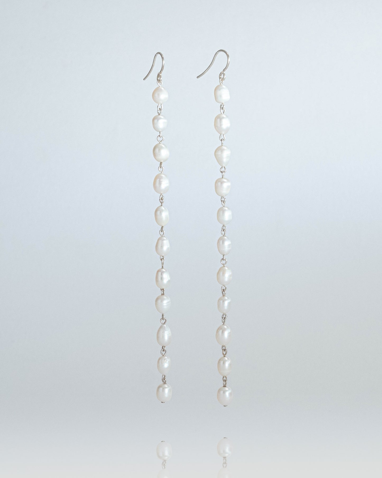 Long freshwater pearl earrings with luminous pearls and silver hooks, 14 cm in length, perfect for elegant and timeless styling.