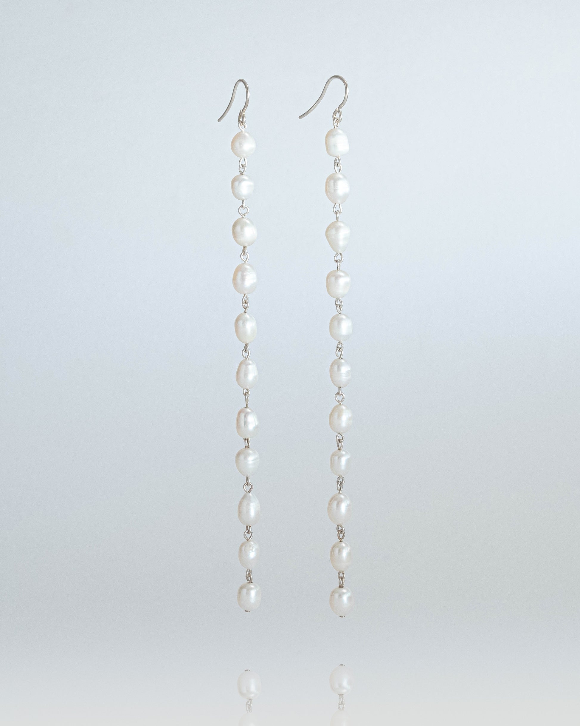 Long freshwater pearl earrings with luminous pearls and silver hooks, 14 cm in length, perfect for elegant and timeless styling.