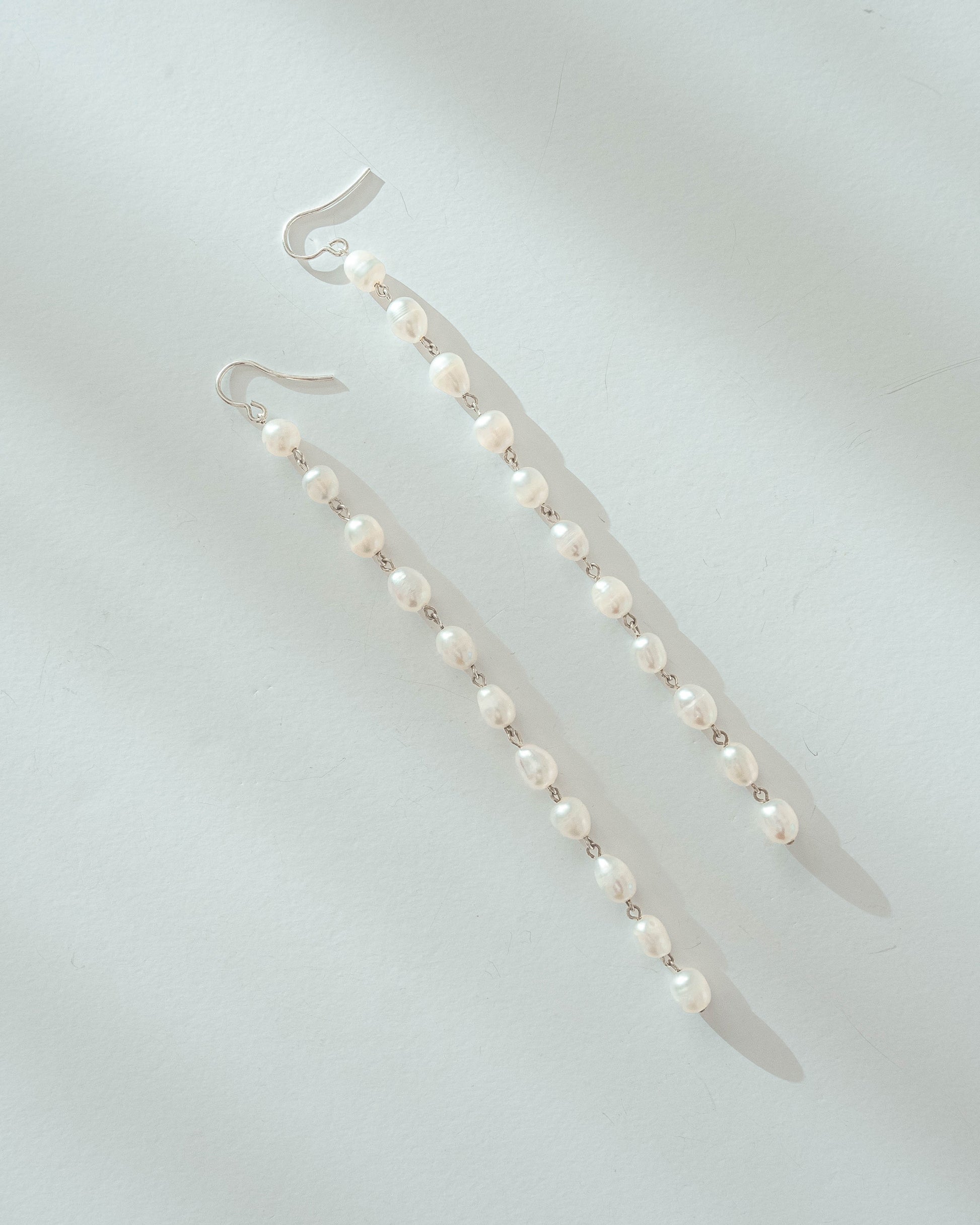 Long freshwater pearl earrings with luminous pearls and silver hooks, 14 cm in length, perfect for elegant and timeless styling.