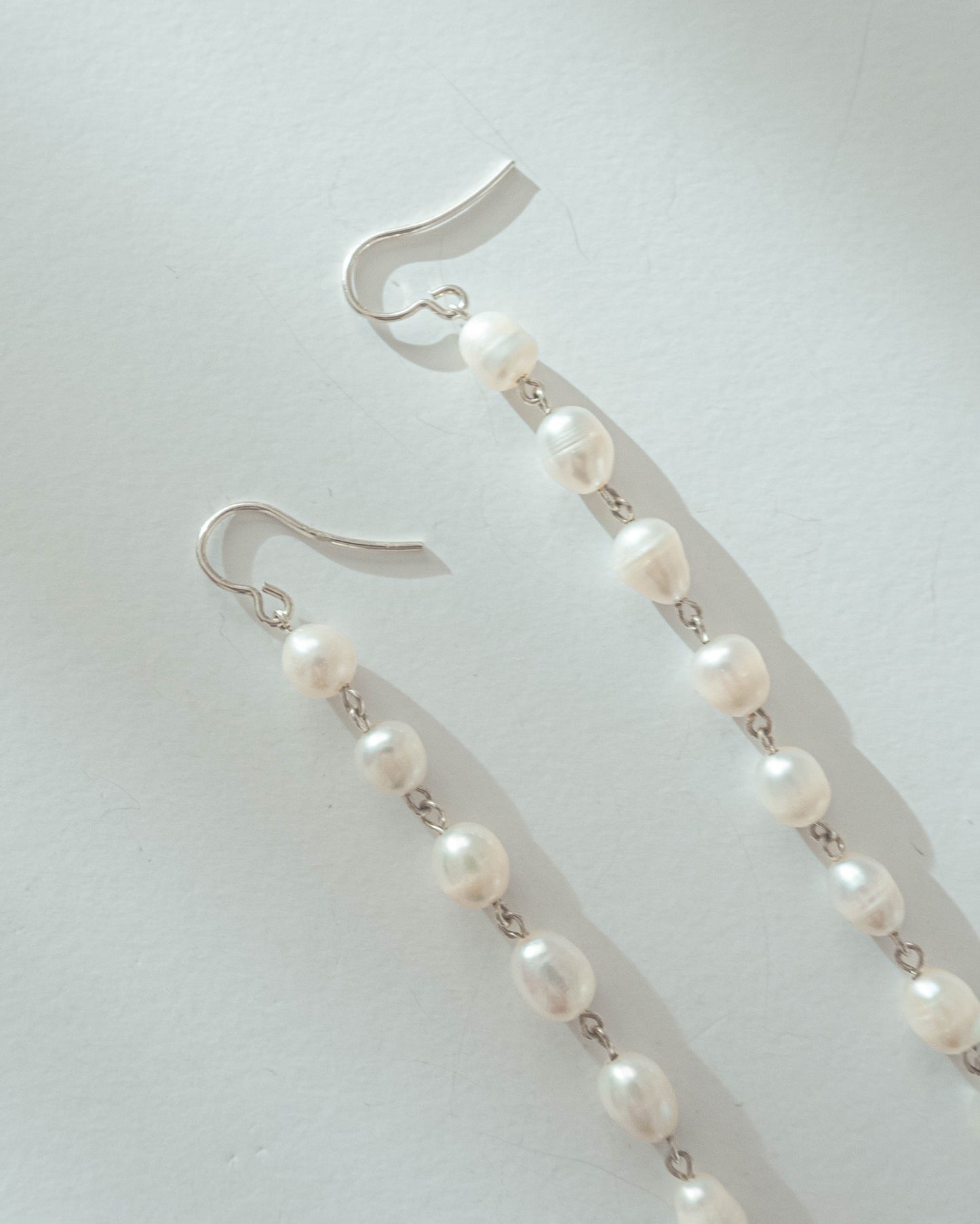 Long freshwater pearl earrings with luminous pearls and silver hooks, 14 cm in length, perfect for elegant and timeless styling.