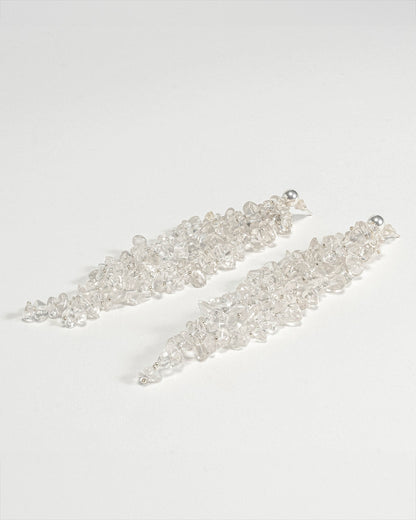 Long chunky dangling earrings featuring jagged clear quartz stones with silver hooks, 10 cm in length, offering bold and elegant design.
