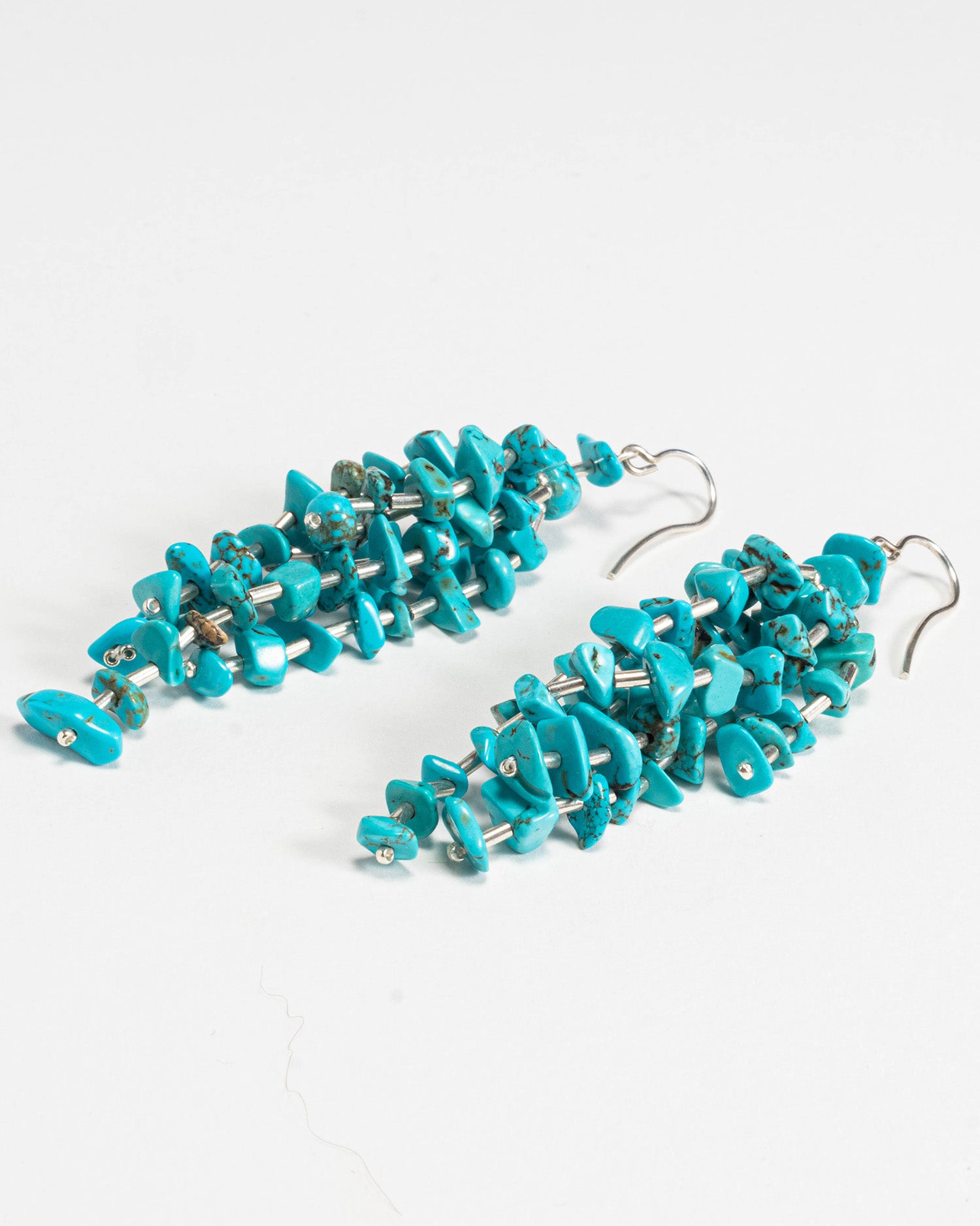 Turquoise stone fringe earrings featuring vibrant turquoise stones with silver hooks, 9 cm in length, offering a long and elegant design.