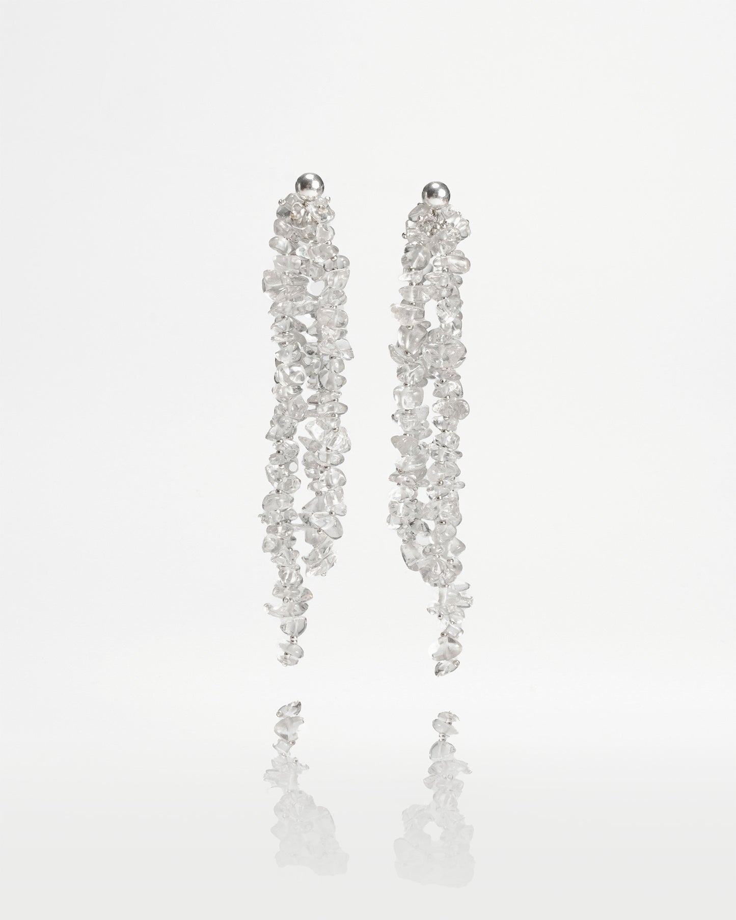 Long chunky dangling earrings featuring jagged clear quartz stones with silver hooks, 10 cm in length, offering bold and elegant design.