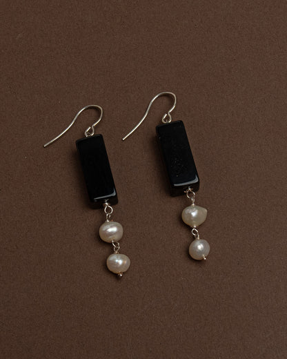 Minimalist earrings with baroque pearls and black agate. Handmade sterling silver drop earrings for modern elegance and everyday sophistication.