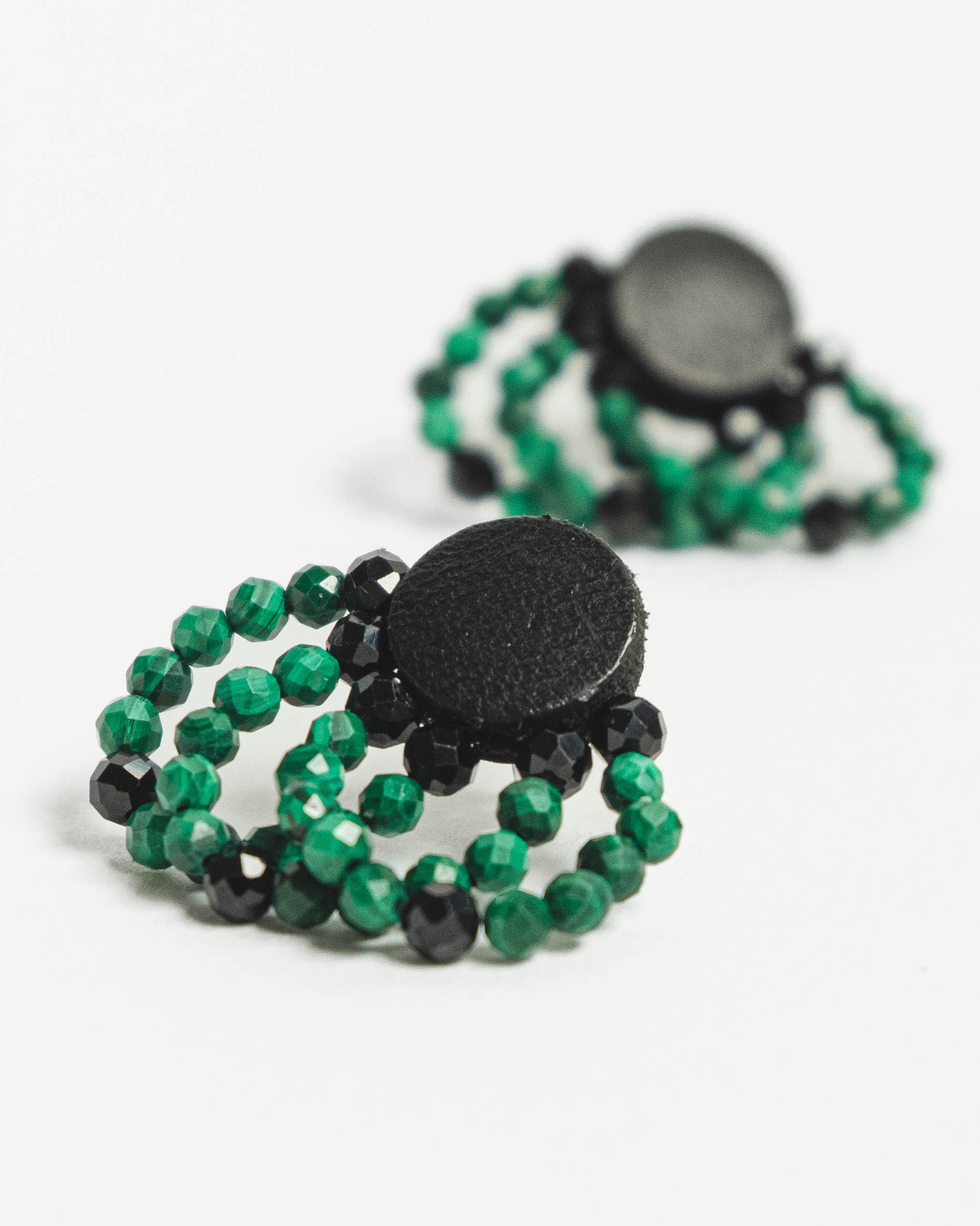 Malachite bead and leather earrings with silver studs, 2 cm in length, offering a bold and modern design.