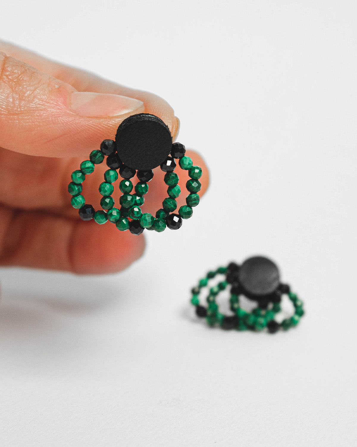 Malachite bead and leather earrings with silver studs, 2 cm in length, offering a bold and modern design.